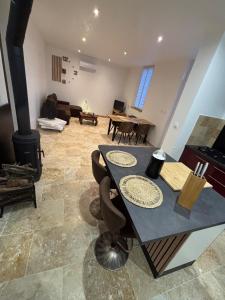 a living room with a table and a fireplace at Maison au calme à Pessac Sur Dordogne in Pessac-sur-Dordogne