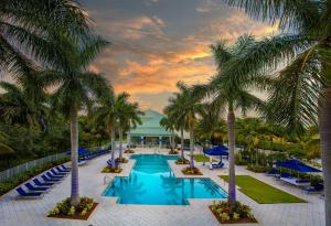 un complejo con piscina con palmeras y sillas en Stylish Apartment 1BR - 2BTH, en Miami