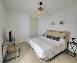 a white bedroom with a bed and a chair at Arguineguin Sun Beach in Arguineguín