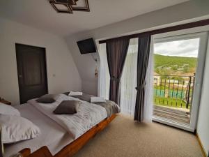 a bedroom with two beds and a large window at Villa Perule 2 Вила Перуле in Shumnatitsa