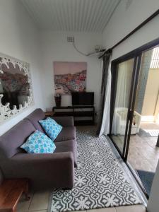 a living room with a couch and a tv at Ocean Rush Dolphin in Zinkwazi Beach