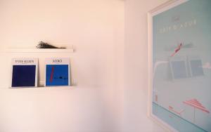 a white wall with three pictures on a wall at Bel appartement 3 pièces en villa climatisé 800m plage WIFI in Cavalaire-sur-Mer