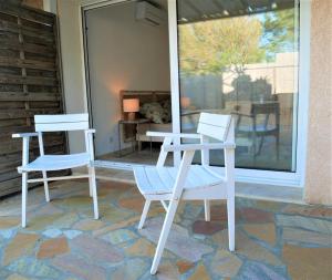 two white chairs and a table on a patio at Bel appartement 3 pièces en villa climatisé 800m plage WIFI in Cavalaire-sur-Mer