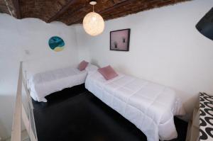 two beds in a room with white walls at Art house Charcas in Buenos Aires