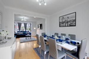 a dining room and living room with a table and chairs at Stylish 3BR House Close to Wembley Stadium and Arena in London