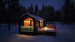 a small cabin in the snow at night at Hossaville Luxe Lake Cabin in Hossa +74 photos