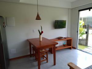 a dining room with a table and a potted plant at Casa Liz in Itacaré