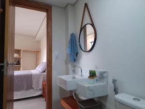 a bathroom with a sink and a mirror and a bed at Casa Liz in Itacaré +17 photos