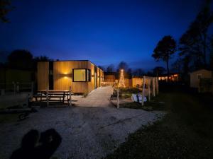 a house is lit up at night with a fence at "Chalet Zanna" privéaccomodatie op park, begaafdzorgtse in Opende