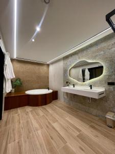 a bathroom with a tub and a sink and a mirror at Hotel La Barrosa in Abejar