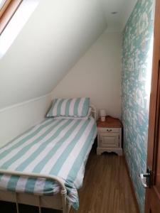 ein kleines Schlafzimmer mit einem Bett im Dachgeschoss in der Unterkunft Hytheview Cottage Whitehills in Whitehills