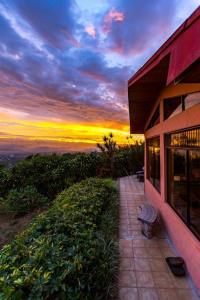 a bench sitting next to a building with a sunset at Stunning Views from Coffee Country Villa - 25 min to SJO in Pilas