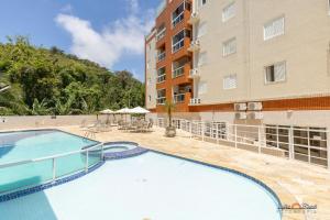 a swimming pool in front of a building at Melhor Local Praia Grande Ubatuba in Ubatuba