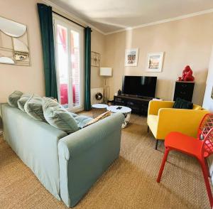 a living room with a couch and a tv at Appartement Marceau in Mers-les-Bains