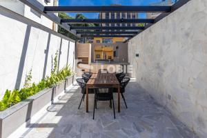 a patio with a wooden table and chairs at Lobie Gloria Del'Art in Rio de Janeiro