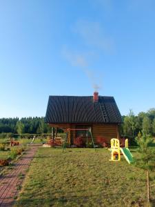 una casa con un parque infantil delante en Sauna&Relax, en Sakstagals