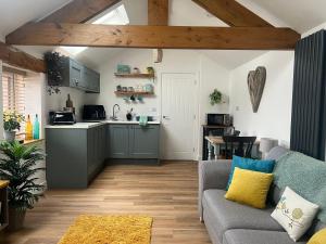 un salon avec un canapé et une cuisine dans l'établissement 200 yr old Barn Conversion ,Near Carlisle, the Borders and the North Pennines in peaceful village location, à Castle Carrock