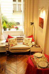 a room with a couch in front of a window at Le Studio Flore in Paris