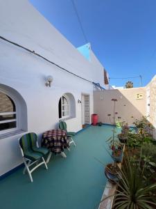 a patio with chairs and plants on a building at Heimat am Meer in Sidi Ifni