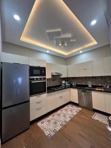 a large kitchen with stainless steel appliances and a rug at Heimat am Meer in Sidi Ifni