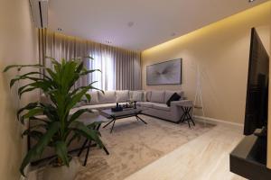 Una sala de estar con un sofá y una planta. en شقه 3فاخره ثلاث غرف نوم, en Riad