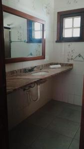 a bathroom with a sink and a mirror at Pousada castelo princesinha do Sul in Ilhéus