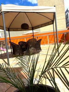 a table and chairs under an umbrella on a patio at Hotel Verdes Mares in Ouro Branco