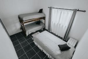 a small bedroom with two beds and a window at Cabañas Altos del Volcán in Villarrica