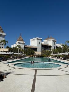 a pool in front of a building with people in it at Luxurious 2 Bedroom Upscale Condo in Nuevo Vallarta 