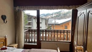 a bedroom with a large window with a view at Appartement 2 pieces LE SAPPORO in Les Gets +5 photos