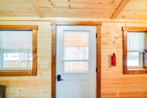een witte deur in een houten kamer met twee ramen bij La Grange Cabin on a Racehorse Farm with Pond Views! in La Grange +16 foto's