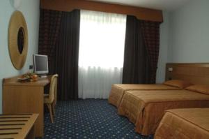 a hotel room with two beds and a desk and a window at Hotel Panorama in Cambiano +86 photos