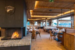 restauracja z kominkiem, stołami i krzesłami w obiekcie BichlAlm Berggasthof w mieście Kitzbühel