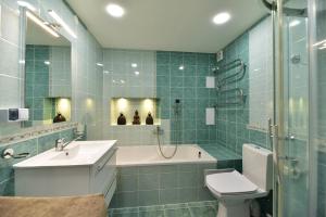 een badkamer met een bad, een wastafel en een toilet bij Oksanos Apartamentai Druskininku centre in Druskininkai