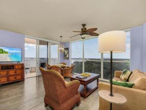 フォートマイヤーズビーチにあるPerfect Island Escape - Beach, Pool, Restaurant & More! -FMB-Condo Island Oasis - Roelensのソファと椅子とテレビのあるリビングルーム