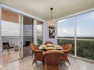 フォートマイヤーズビーチにあるPerfect Island Escape - Beach, Pool, Restaurant & More! -FMB-Condo Island Oasis - Roelensのテーブルと椅子と窓のあるダイニングルーム