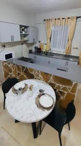 una mesa blanca y sillas en una cocina con encimera en Epitome of Comfort - One Bedroom, en Naivasha