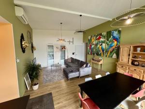 a living room with a couch and a table at Villa Napoléni - Maison - Calme - Jardin - Parking in La Roche-sur-Yon