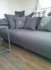 a couch with pillows on it in a room at Sealodge II Huus & Meer in Ortmühle +10 photos