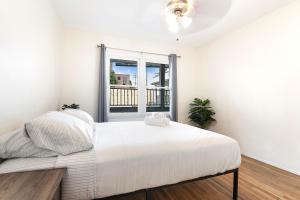 a white bedroom with a large bed and a window at Second-Floor 1-BR Near Beverly Hills and Top Los Angeles Attractions in Los Angeles