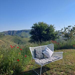 une chaise en osier blanc dans un champ de fleurs dans l'établissement Villa Ferranti Abruzzo, à Montefino