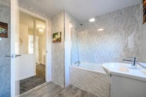 a bathroom with a tub and a sink and a shower at -RCGS- For your relaxed, Cosy Stay, Free Parking in Leeds +18 photos