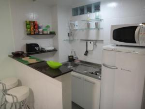 una pequeña cocina con fregadero y microondas en Ajuricaba Suites 1, en Manaus