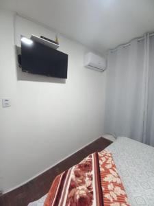 una camera da letto con un letto e una TV a parete di Hotel El-Shaday a Vila Nova do Sul