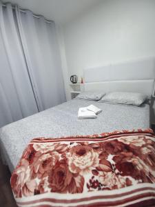 una camera da letto con un letto con una coperta floreale sopra di Hotel El-Shaday a Vila Nova do Sul Altre 5 foto