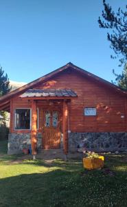 a log cabin with a porch and a door at Entre Cerros Tiny House Única in Moquehue