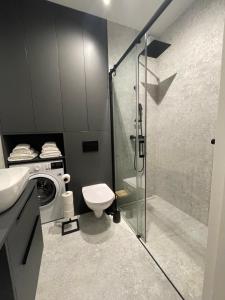 Un baño con inodoro y lavadora. en Apartamenty Wawrzyńca Goplana parking, en Poznan 14 fotos más