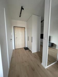 Habitación vacía con puerta y suelo de madera en Apartamenty Wawrzyńca Goplana parking, en Poznan