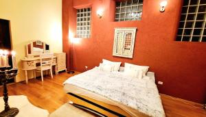 a bedroom with a bed and a red wall at Muresenilor 16 Residence in Braşov +16 photos