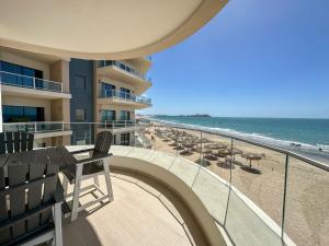 a balcony with chairs and umbrellas and the beach at Modern 2BR Gem oIconic Sandy Beach in Puerto Peñasco